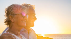 happy older couple looking at the sunrise